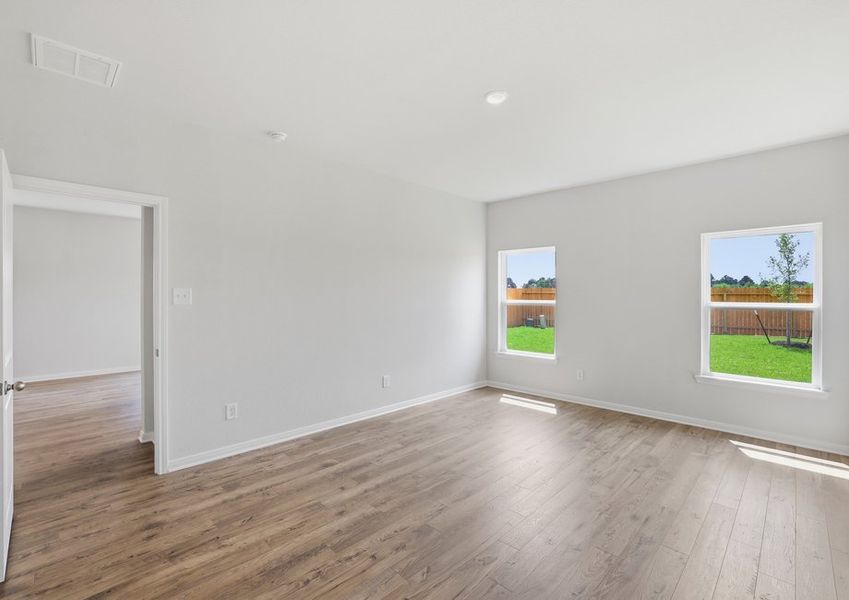 Secondary bedroom featuring windows and wood-look flooring.
