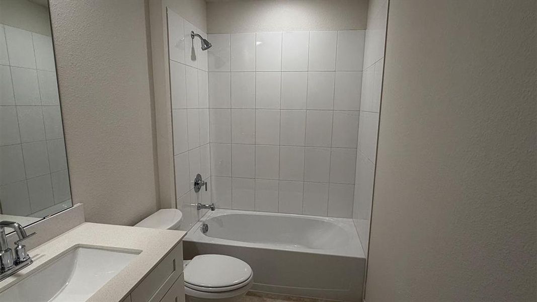 Full bathroom featuring a white porcelain tub and shower combination with white tile surround