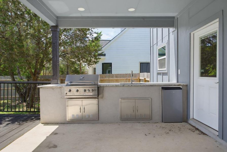 An outdoor kitchen with a built-in grill and sink, perfect for entertaining. An outdoor kitchen with a built-in grill and sink, perfect for entertaining.