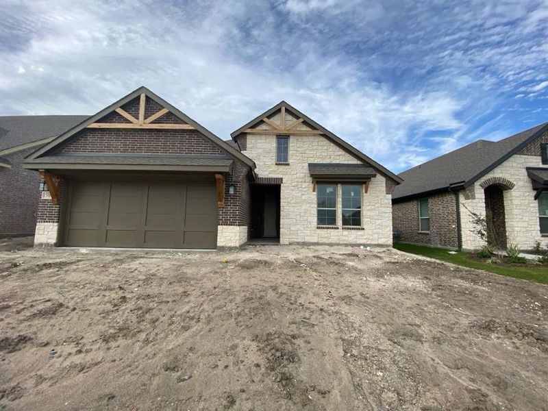 Striking exterior featuring a combination of light-toned stone and dark brick