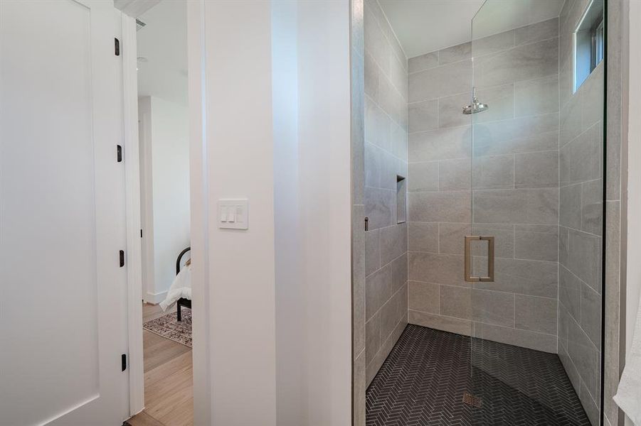 Full bath with a shower stall and wood finished floors