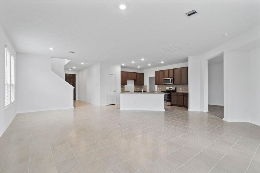 Thoughtfully designed with an open layout, the family room offers clear sightlines to the entryway, ensuring you remain effortlessly connected to guests and family the moment they step through the front door.