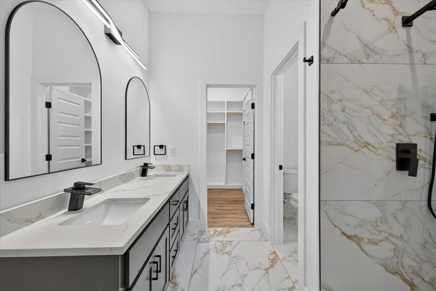 Bathroom featuring a dual vanity with rectangular undermount sinks, black hardware, and an expansive countertop Bathroom featuring a dual vanity with rectangular undermount sinks, black hardware, and an expansive countertop