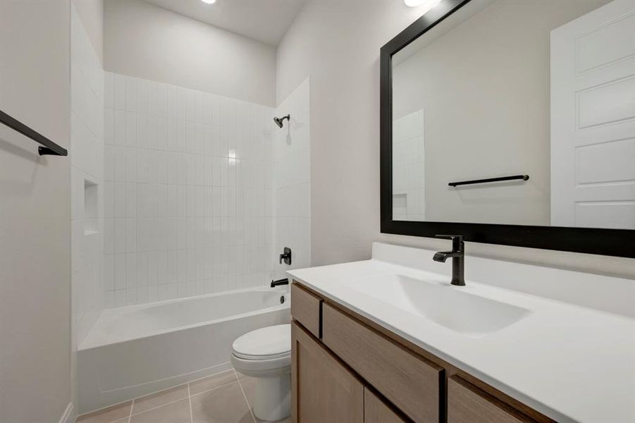 Bathroom featuring vanity, bathing tub / shower combination, and light tile patterned floors
