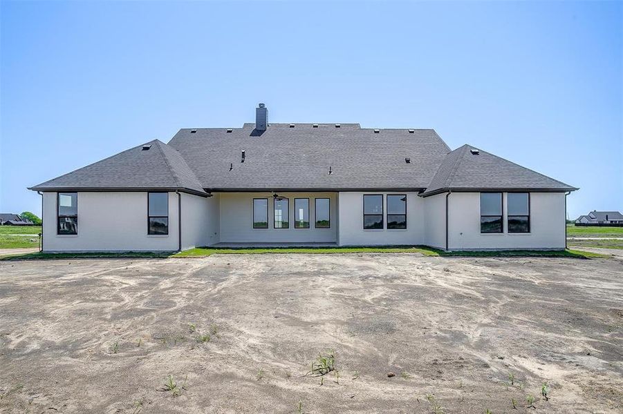 Rear view of house featuring roof with shingles and a chimney Rear view of house featuring roof with shingles and a chimney
