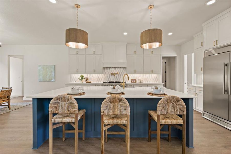 Kitchen with built in fridge, recessed lighting, light countertops, light wood finished floors, and decorative backsplash Kitchen with built in fridge, recessed lighting, light countertops, light wood finished floors, and decorative backsplash