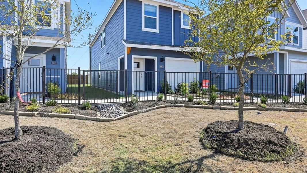 View of front of property with a fenced front yard and an attached garage
