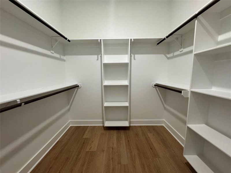 Walk in closet with dark hardwood / wood-style flooring