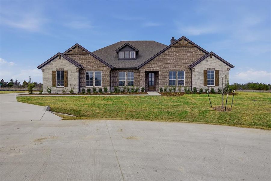 Craftsman-style house featuring brick siding, a chimney, and a front lawn