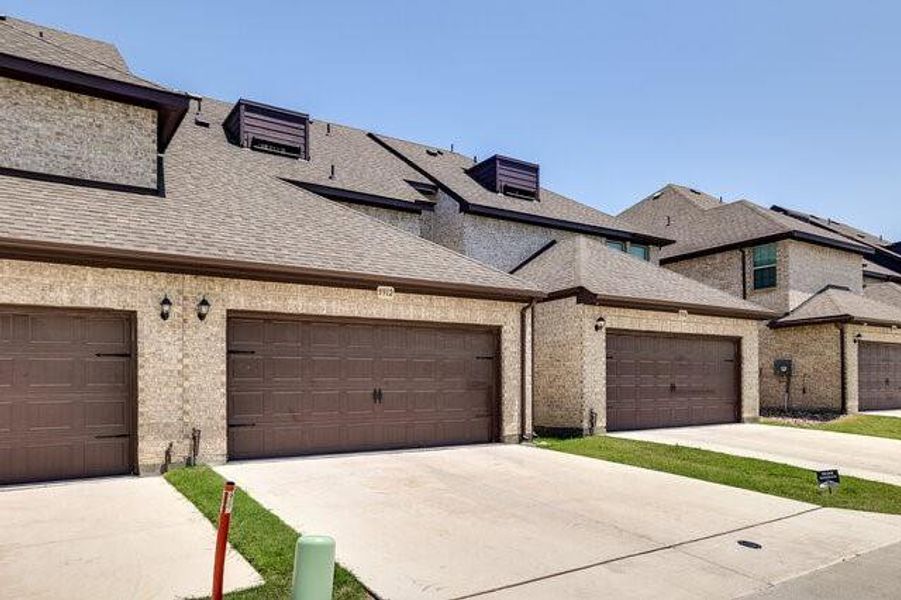 View of front of house featuring concrete driveway, a shingled roof, and an attached garage