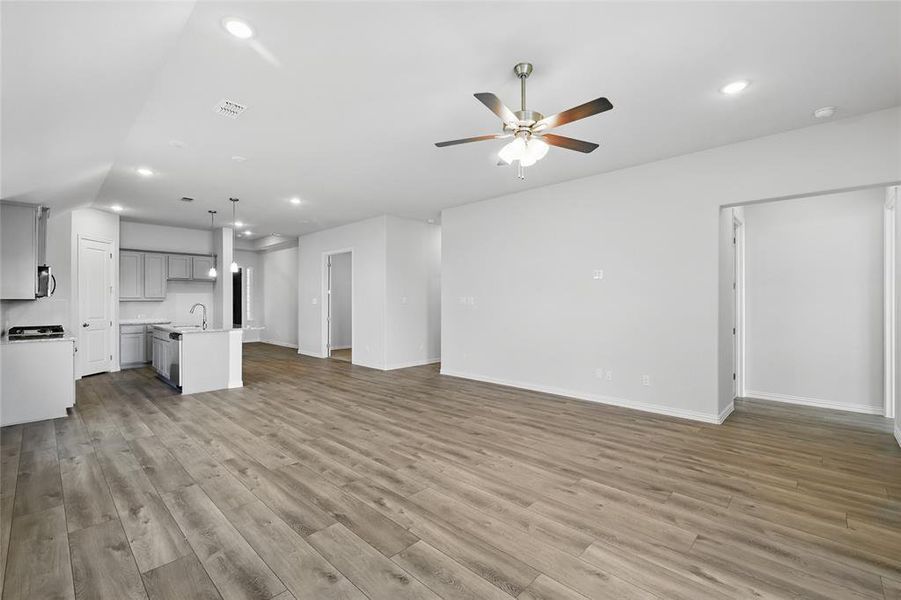 Unfurnished living room featuring a ceiling fan, recessed lighting, light wood-style flooring, and baseboards Unfurnished living room featuring a ceiling fan, recessed lighting, light wood-style flooring, and baseboards