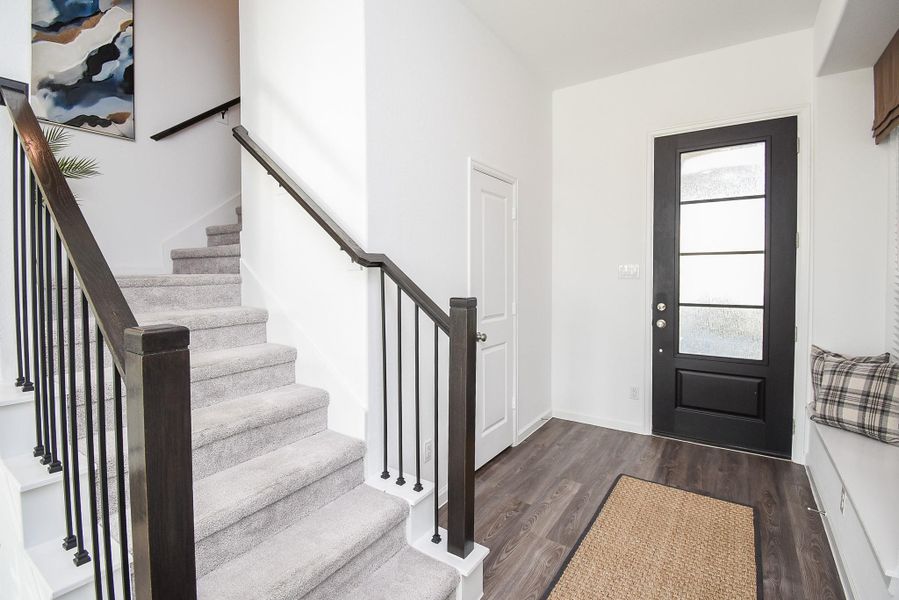 A bright and welcoming foyer with sleek stairs and contemporary finishes.