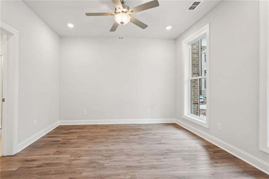 Empty room featuring light wood-style floors, a ceiling fan, and recessed lighting