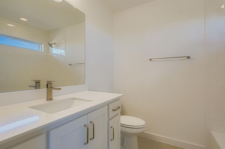 Bathroom with vanity, light tile patterned flooring, shower / bath combination, and recessed lighting Bathroom with vanity, light tile patterned flooring, shower / bath combination, and recessed lighting