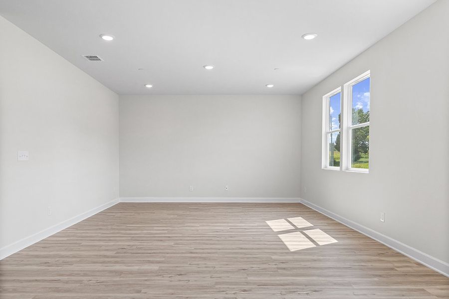 A room with a wood floor and windows.