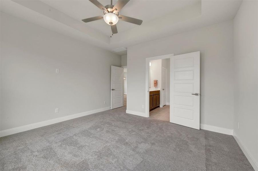 Spacious room with tray ceiling and contemporary ceiling fan