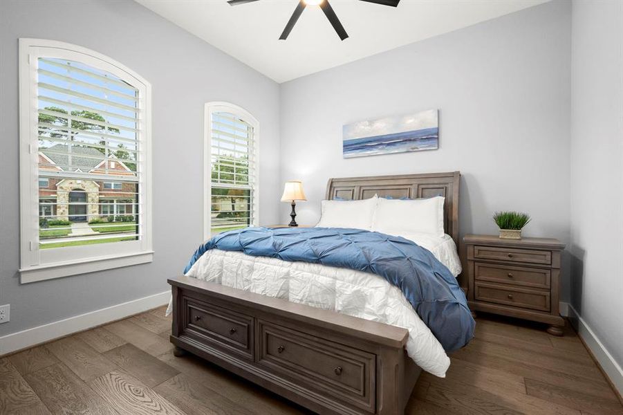 Second bedroom with hardwood floors, plantation shutters, built-in cabinets in closet and 5" baseboards