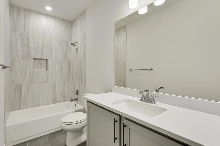 Bathroom with vanity, shower / bathtub combination, and tile patterned flooring