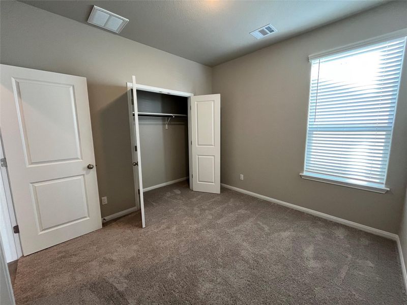 Middle bedroom. A spacious bedroom features neutral walls, wall-to-wall carpeting, and a built-in closet. Middle bedroom. A spacious bedroom features neutral walls, wall-to-wall carpeting, and a built-in closet.