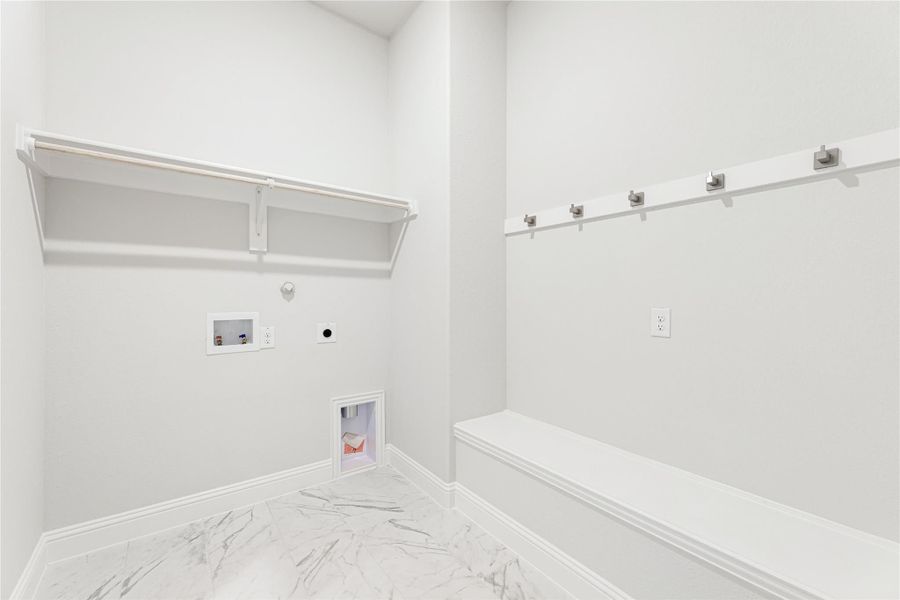 Laundry and mudroom area with white walls, built-in bench, coat hooks, shelf, and marble-look tile floors