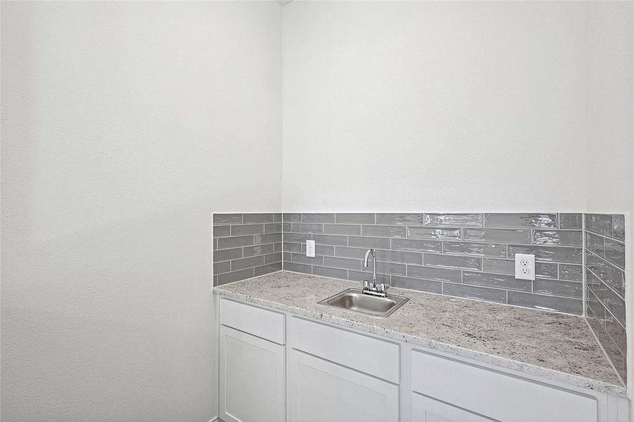 Bathroom featuring decorative backsplash and sink