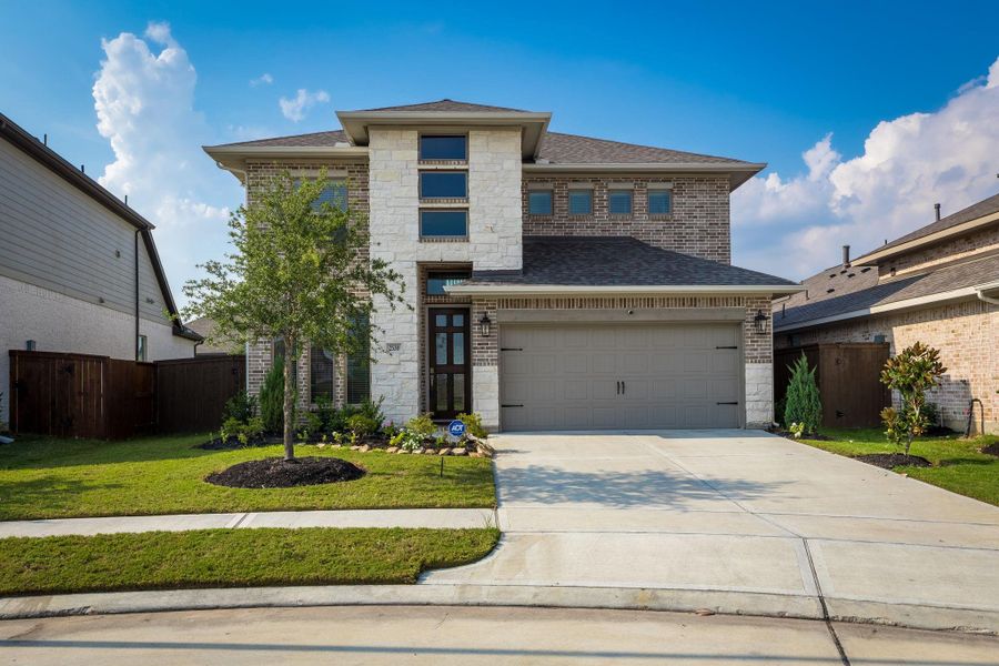 Front exterior of a new home in Cane Island 50', Katy, TX, highlighting curb appeal (Image 26). Front exterior of a new home in Cane Island 50', Katy, TX, highlighting curb appeal (Image 26).