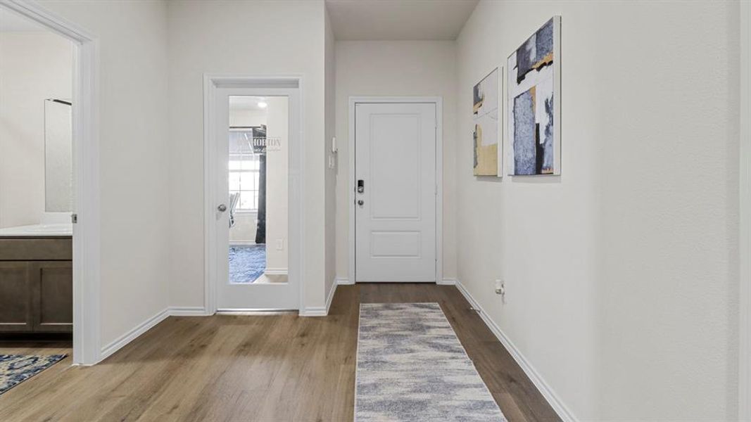 Doorway to outside with wood finished floors and baseboards