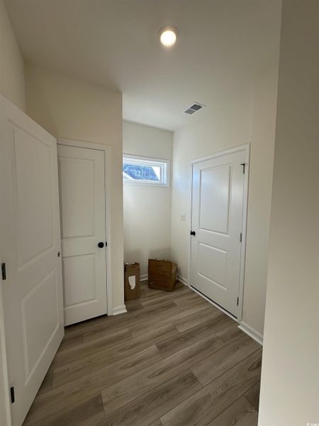 Hallway with wood finished floors and baseboards
