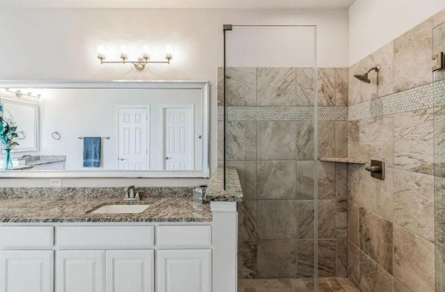 Bathroom with vanity and tiled shower