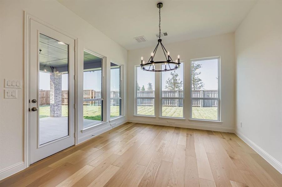 Unfurnished dining area with light wood-style floors and a chandelier