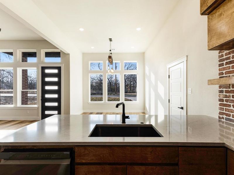 Kitchen with dishwasher, light stone counters, decorative light fixtures, recessed lighting, and healthy amount of natural light Kitchen with dishwasher, light stone counters, decorative light fixtures, recessed lighting, and healthy amount of natural light