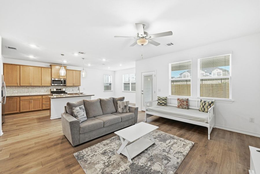 Living room with recessed lighting, a ceiling fan, and light wood-style flooring