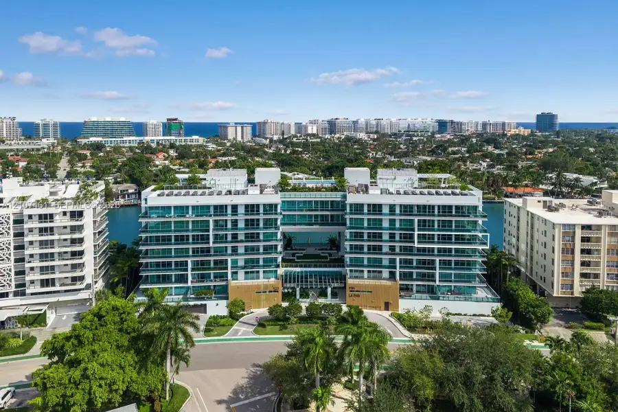 Mid-rise residential building featuring floor-to-ceiling glass windows, wraparound balconies, structured parking, and waterfront positioning Mid-rise residential building featuring floor-to-ceiling glass windows, wraparound balconies, structured parking, and waterfront positioning