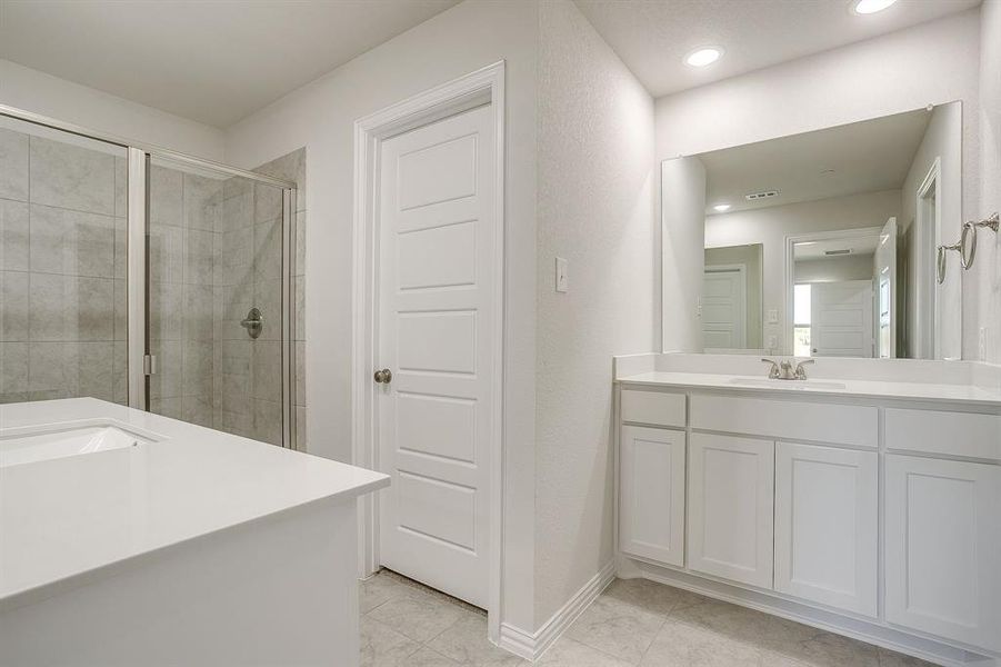 Bathroom featuring a stall shower, vanity, recessed lighting, and light tile patterned flooring