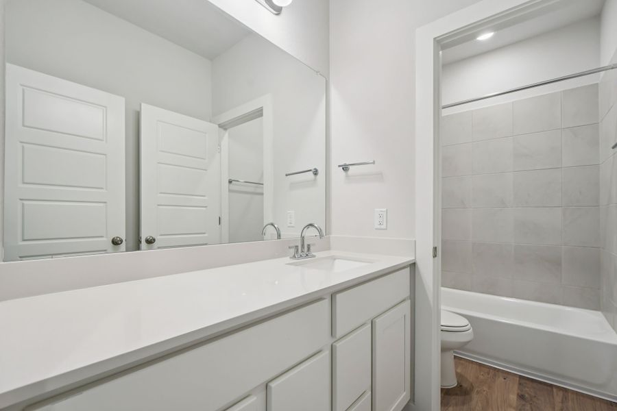 A bathroom with white cabinets.