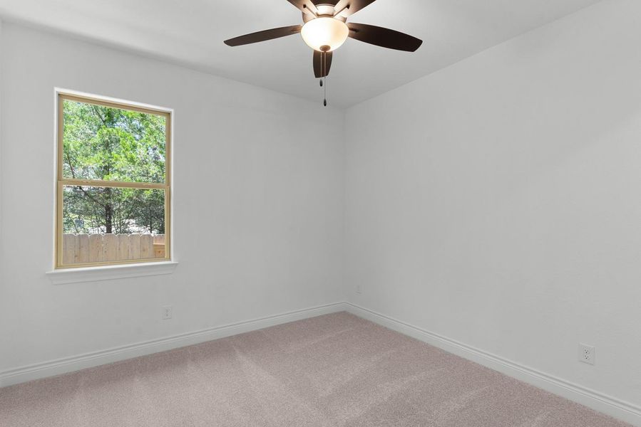 Well-lit room provides a tranquil space, perfect for rest or study, featuring a ceiling fan for comfort.