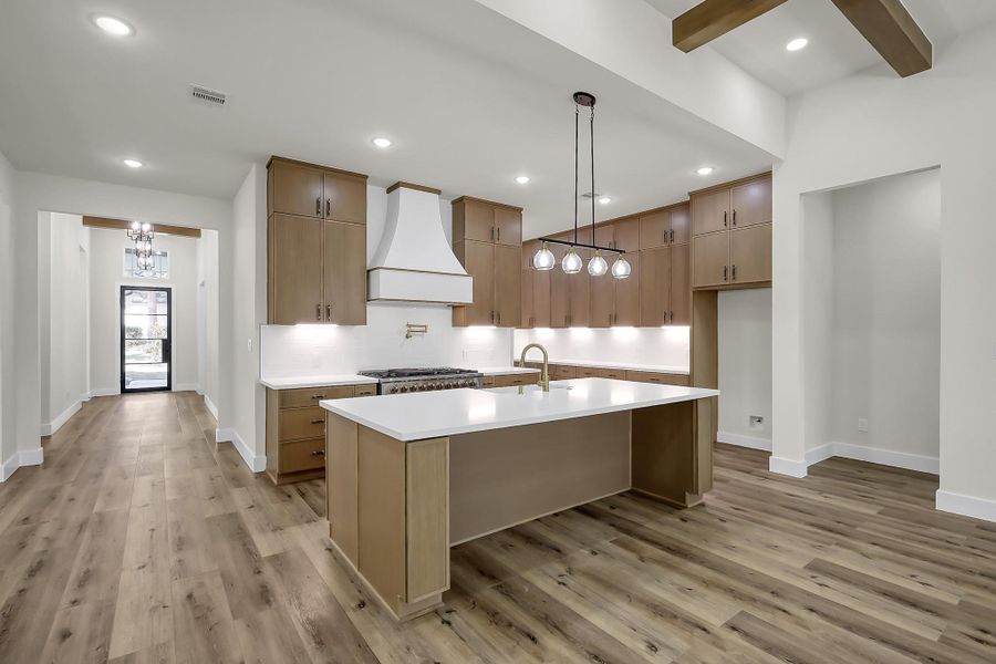 The chef’s dream kitchen features an oversized granite island, six burner range with grill and double oven, stainless steel dishwasher and microwave, farm sink and under cabinet lighting.