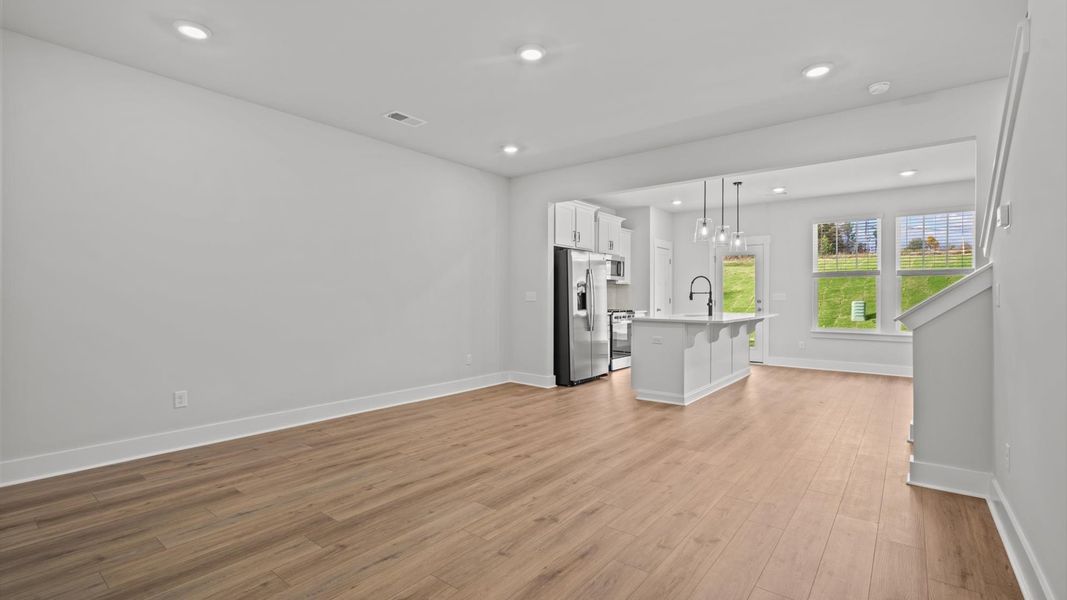 Spacious family room with rich hardwood flooring and elegant trim work in a reputable DRB Homes build Spacious family room with rich hardwood flooring and elegant trim work in a reputable DRB Homes build