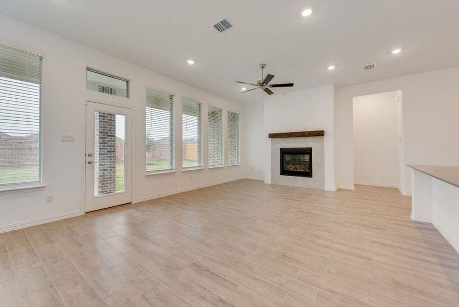 Unfurnished living room featuring ceiling fan and light wood-type flooring