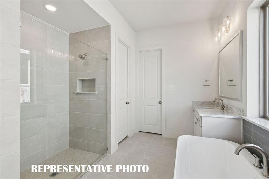 Featuring a spacious walk in shower and free standing tub, this owner's bath is everything you have been searching for.  REPRESENTATIVE PHOTO