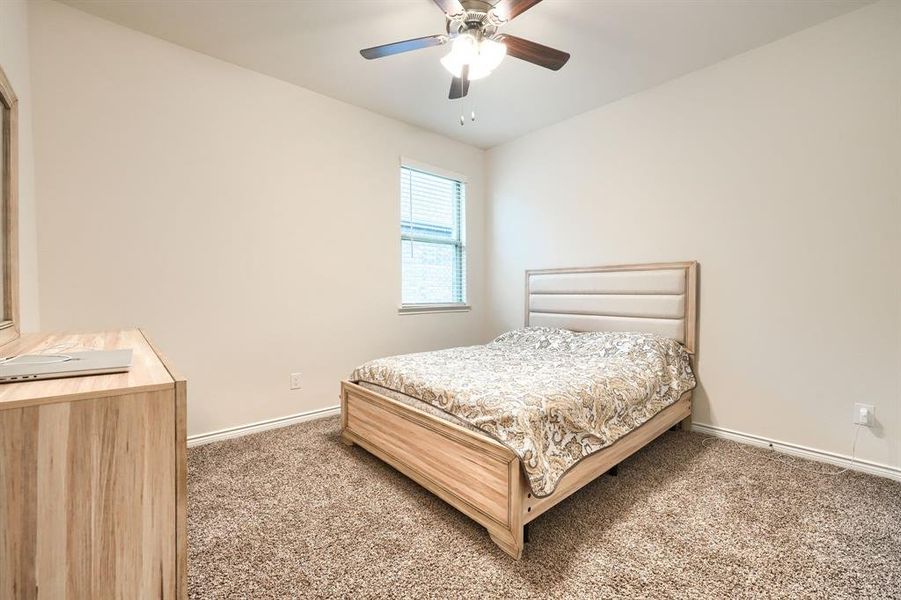Bedroom with a ceiling fan and carpet flooring Bedroom with a ceiling fan and carpet flooring