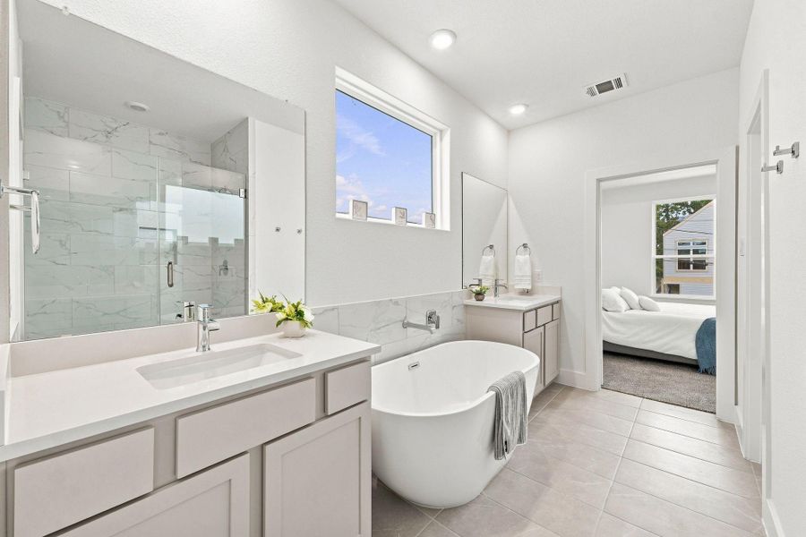 Beautiful primary bath combining a freestanding soaking tub, separate glass-enclosed shower, dual vanities and contemporary finishes for a relaxing retreat. Beautiful primary bath combining a freestanding soaking tub, separate glass-enclosed shower, dual vanities and contemporary finishes for a relaxing retreat.
