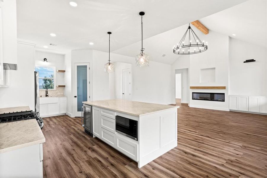 Kitchen featuring white cabinets, hanging light fixtures, recessed lighting, dark wood-style floors, and beamed ceiling Kitchen featuring white cabinets, hanging light fixtures, recessed lighting, dark wood-style floors, and beamed ceiling