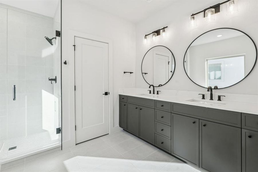 Primary bathroom with dual sinks and framed mirrors.