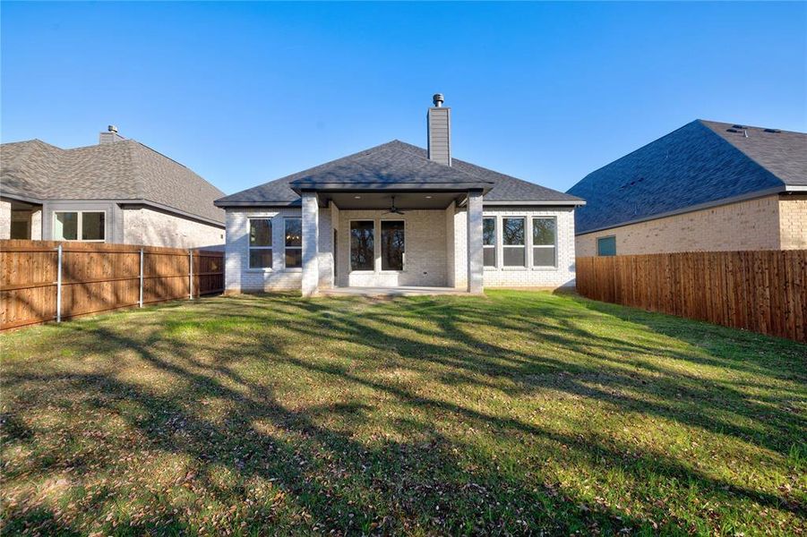 Back of property with a lawn, ceiling fan, and a patio area