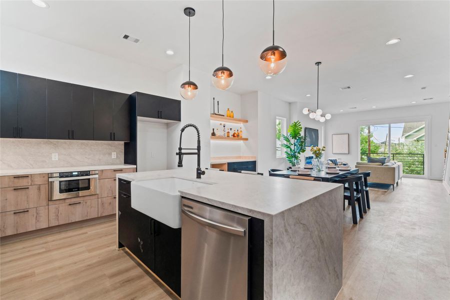 This kitchen pairs a large single-basin farmhouse sink on the island with a sleek microwave drawer built into the surrounding cabinetry, creating an elegant and integrated look. This kitchen pairs a large single-basin farmhouse sink on the island with a sleek microwave drawer built into the surrounding cabinetry, creating an elegant and integrated look.