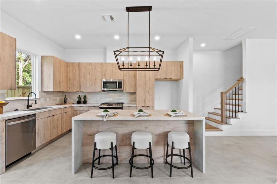 Arcadia Yellow Walnut cabinetry with Artic White with Coral Luster Quartz Countertops.