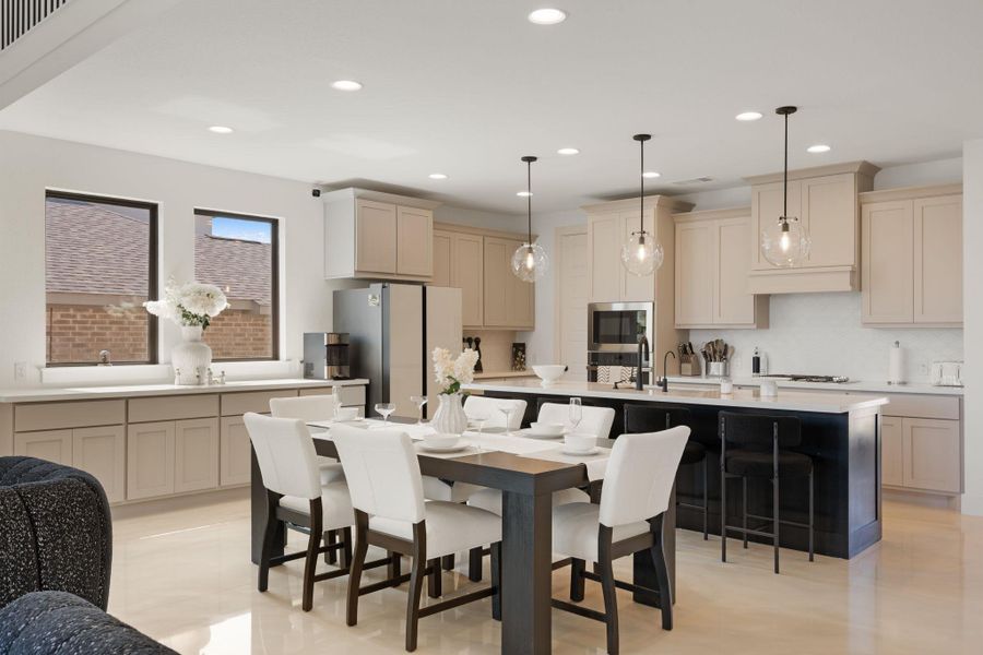 A well-lit kitchen featuring an inviting dining area and an expansive island with bar seating. A well-lit kitchen featuring an inviting dining area and an expansive island with bar seating.