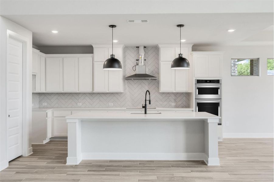 Kitchen featuring tasteful backsplash, wall chimney range hood, wood finish floors, light stone countertops, and recessed lighting