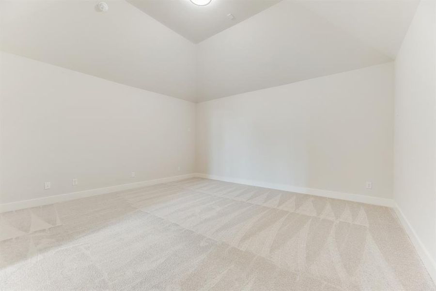 Spare room with light carpet and lofted ceiling Spare room with light carpet and lofted ceiling